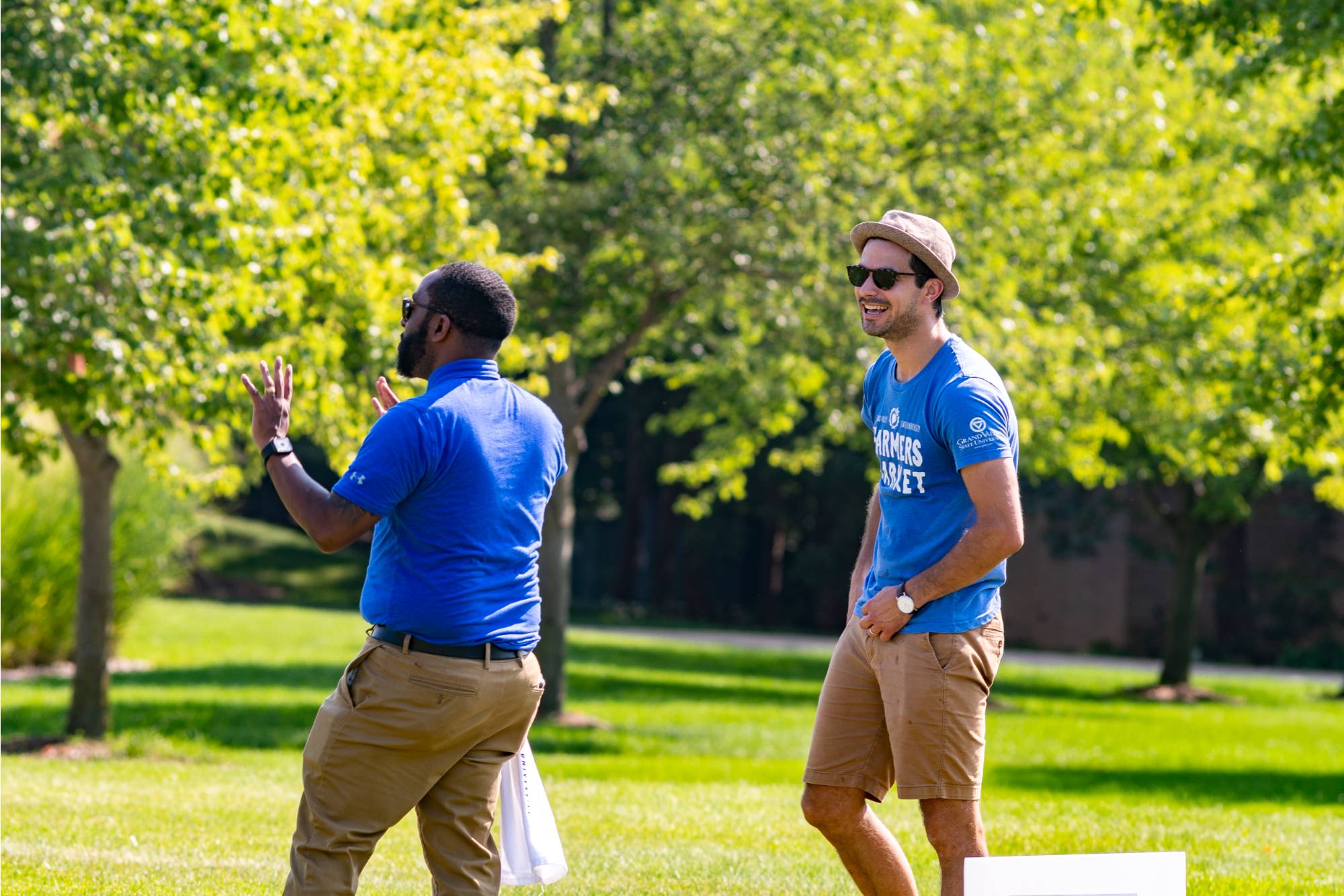 Alex Priebe laughing with a colleague at the first ever GVSU cornhole tournament for employees